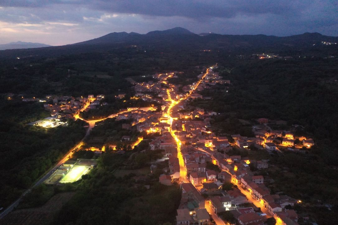 Vista aerea notturna di Casale di Carinola con le luci del borgo e il Roccamonfina sullo sfondo